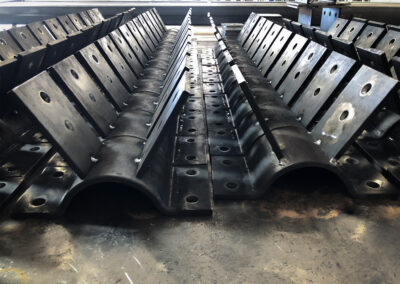 Tower leg clamps on floor of fabrication plant